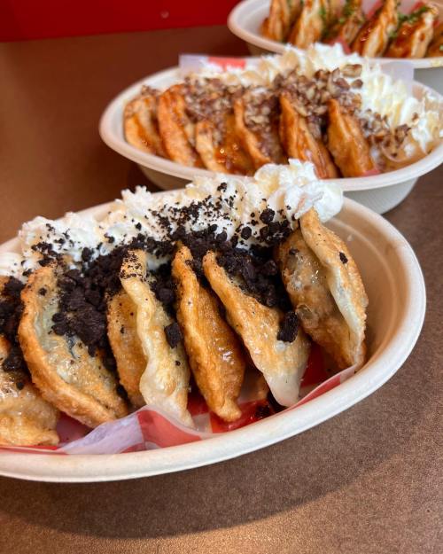 A close-up of two bowls of crispy dumplings, one topped with whipped cream and crushed cookies, the other with various toppings.