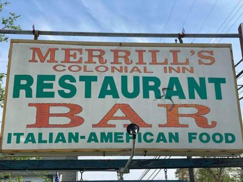 Sign for Merrill's Colonial Inn featuring "Restaurant" and "Bar" with a focus on Italian-American food.