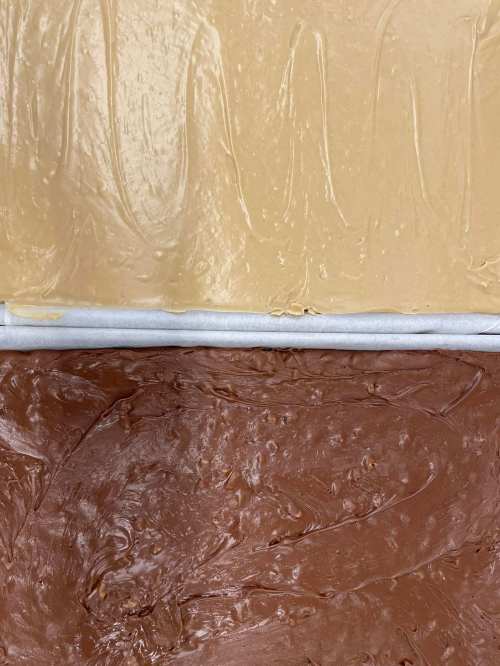 Layers of creamy frosting: a light beige layer on top and a rich brown layer below, both smooth and glossy.