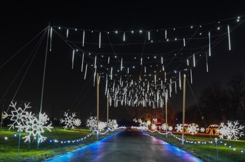 A festive pathway illuminated with hanging lights and snowflake decorations, creating a magical winter atmosphere.