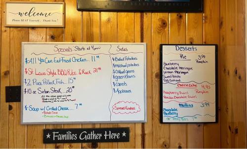 Menu board featuring daily specials, soups, and desserts with prices, set in a rustic wooden environment.
