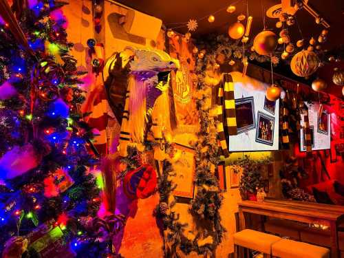 A festive room decorated with colorful lights, a Christmas tree, and sports memorabilia on the walls.