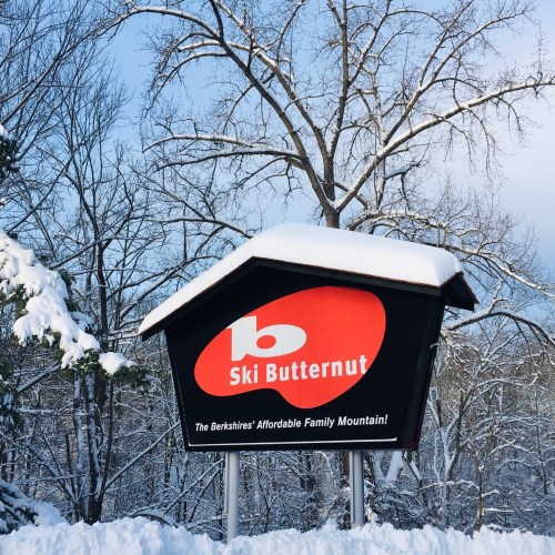 Sign for Ski Butternut, a family-friendly ski resort, surrounded by snow-covered trees.