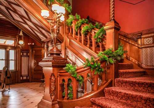 A beautifully decorated wooden staircase with greenery, set in a richly detailed interior.