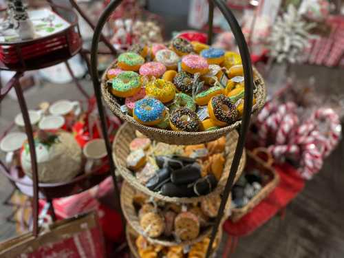 A tiered display of colorful donuts and festive treats, surrounded by holiday decorations and candy canes.