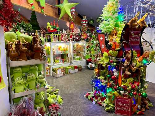 A festive holiday shop filled with green decorations, plush toys, and a brightly lit Christmas tree and sleigh.