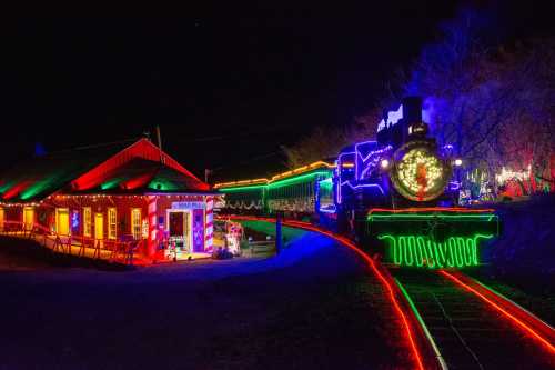 A brightly lit train and station decorated with colorful lights at night, creating a festive atmosphere.