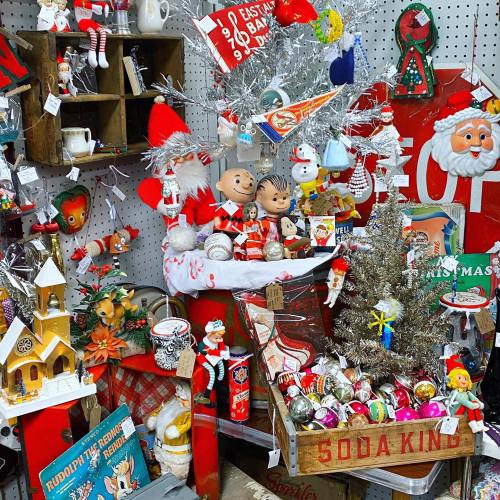 A festive display of vintage Christmas decorations, including ornaments, figurines, and holiday-themed items.