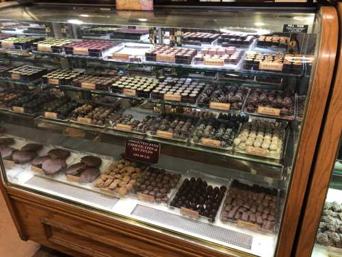 A display case filled with various types of chocolates and confections, showcasing an array of shapes and flavors.