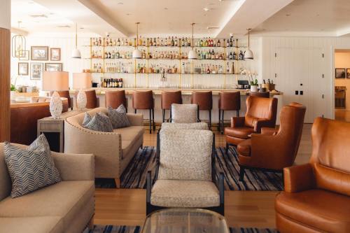A stylish lounge area with comfortable seating and a well-stocked bar in the background.