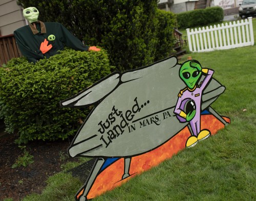 A colorful sign featuring an alien and a spaceship, with the text "Just Landed... in Mars PA," set in a grassy yard.