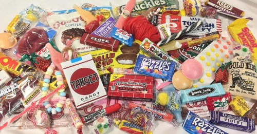 A colorful assortment of various candies, including gummies, chocolates, and nostalgic treats, spread out on a surface.