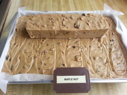 A tray of maple nut fudge, featuring a large block in the center surrounded by a smooth layer of fudge.