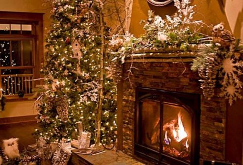 Cozy living room with a decorated Christmas tree, a stone fireplace, and festive decorations. Warm, inviting atmosphere.