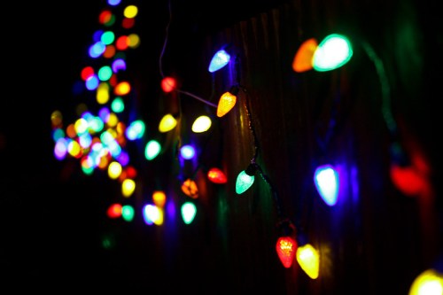 Colorful string lights glowing against a dark background, creating a festive and vibrant atmosphere.
