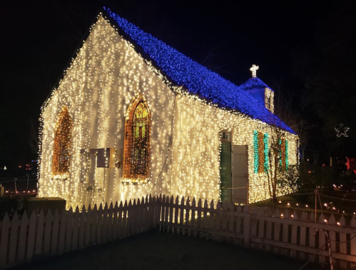 A charming church adorned with bright blue and white lights, glowing beautifully against the night sky.