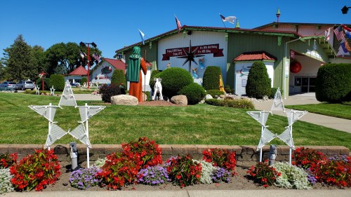 A colorful outdoor scene featuring decorative stars, flowers, and a building with flags and festive decorations.