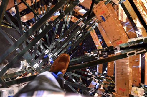 Aerial view of a spiral staircase with numbered steps, featuring a person's foot on the edge.
