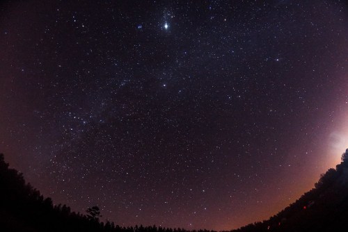 A starry night sky filled with countless stars, with a gradient from dark blue to purple near the horizon.