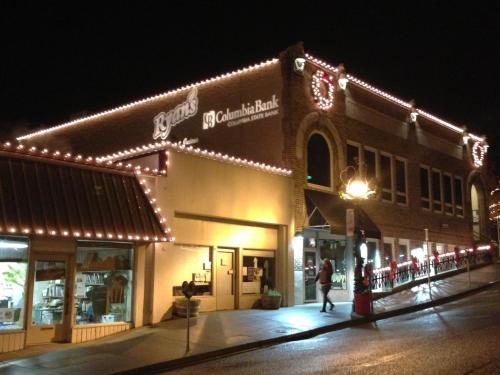 A brightly lit building at night, featuring festive decorations and signage for Columbia Bank.
