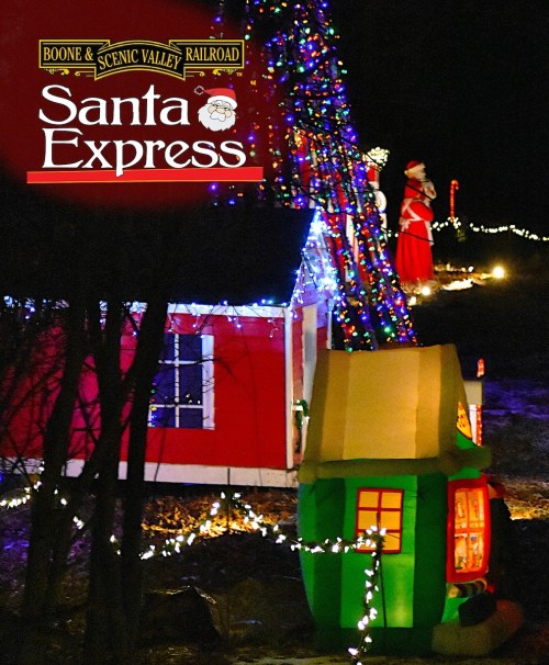 Colorful holiday lights adorn a small house and tree, with a Santa figure in the background, promoting the Santa Express event.