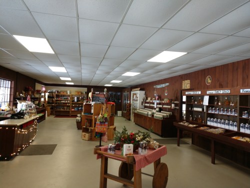 Interior of a cozy shop with wooden shelves, displays of goods, and warm lighting. Decorated for a welcoming atmosphere.