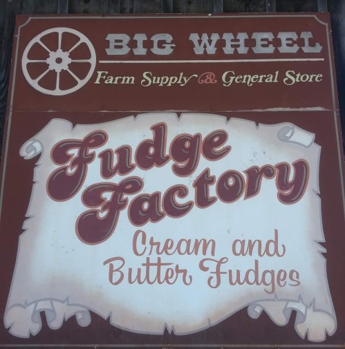 Sign for "Big Wheel Farm Supply & General Store" featuring "Fudge Factory" and "Cream and Butter Fudges."