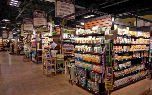 A well-organized grocery store aisle filled with various packaged foods and pet supplies on display.