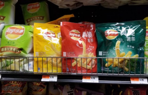 A shelf displaying various Lay's snack bags in colorful packaging, including flavors in green, yellow, and red.