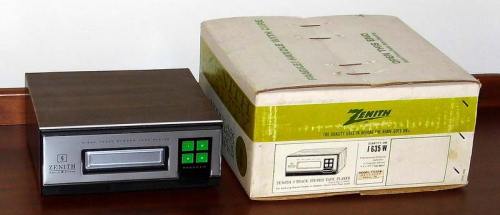 A vintage Zenith tape player next to its original box, featuring a sleek design and green buttons.