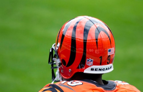 A close-up of a Cincinnati Bengals football helmet, featuring the team's signature tiger stripes and player number 19.
