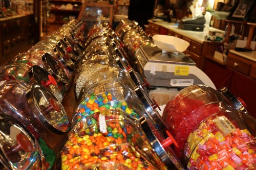 A colorful display of candy jars filled with various sweets in a vintage candy shop.