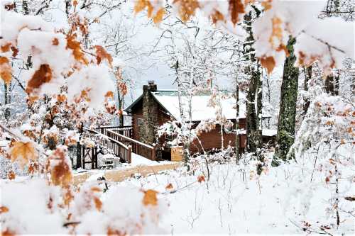 A cozy cabin surrounded by snow-covered trees and autumn leaves, creating a serene winter landscape.