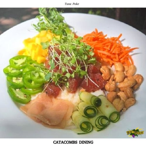 A vibrant tuna poke bowl with rice, mango, jalapeños, carrots, cucumber, and cashews, garnished with microgreens.