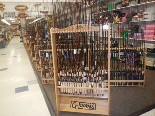 A display of fishing rods arranged on racks in a store, showcasing various styles and sizes.