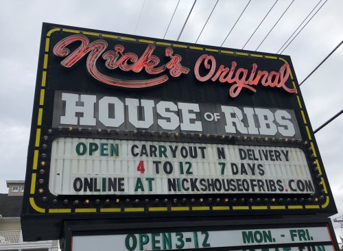 Sign for Nick's Original House of Ribs, featuring hours for carryout and delivery, and website information.