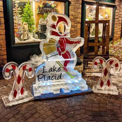 Ice sculptures featuring a skier and candy canes, with "Lake Placid" displayed, set in a festive winter scene.