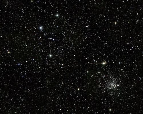 A vast expanse of space filled with countless stars and a cluster of stars in the lower right corner.