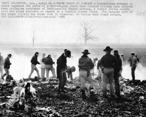 Authorities investigate the wreckage of a plane crash in Arlington, Indiana, with debris scattered across a field.