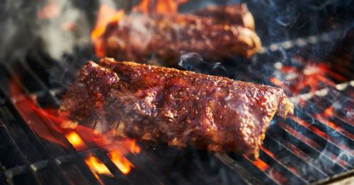 close up of American barbecue ribs smoking on a grill like how they make them in North Carolina