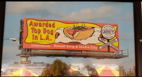Billboard advertising Carney's hot dogs, featuring a colorful design and the text "Awarded Top Dog in L.A."