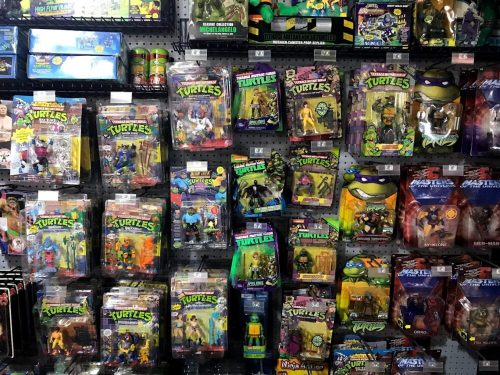 A wall display filled with various action figures, primarily featuring Teenage Mutant Ninja Turtles in packaging.