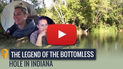 Two people smiling while discussing "The Legend of the Bottomless Hole in Indiana," with a scenic river view in the background.