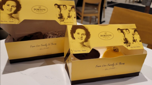 Two yellow boxes from Porto's Bakery, featuring a vintage photo of a woman, labeled "From Our Family to Yours."