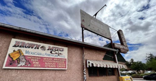 Exterior of Brown Mug Cafe, featuring signs for Mexican and American food, under a cloudy sky.
