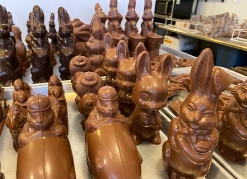 A variety of chocolate bunny and animal figures displayed on a tray in a confectionery shop.