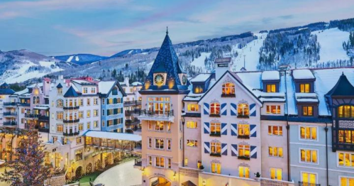 A picturesque snowy mountain resort with charming architecture and twinkling lights at dusk.