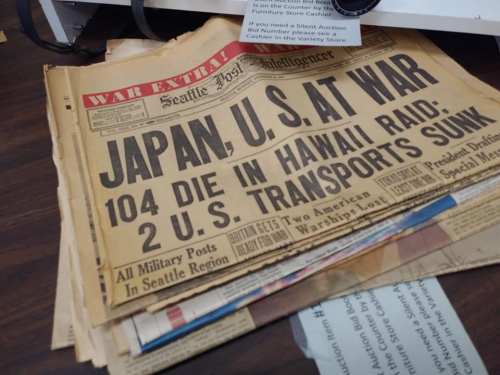 Historic newspaper headline: "Japan, U.S. at War" detailing casualties and transport losses during WWII.