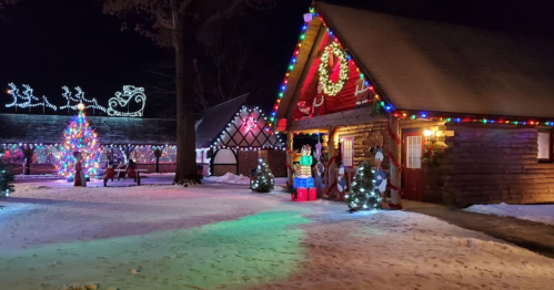 A festive scene featuring a decorated cabin, colorful lights, a Christmas tree, and holiday decorations in the snow.