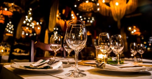 Wine glasses on a table with lights in the background at a fine dining restaurant.